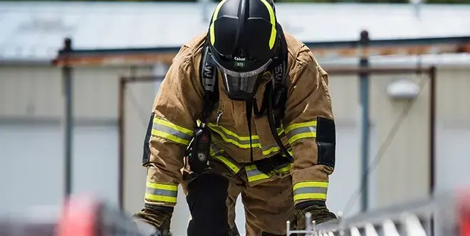 Firefighter wearing MSA Cairns protective gear during emergency response operations, showcasing head protection and firefighter safety equipment.
